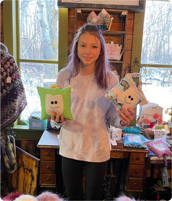 Hannah Forster at The Old Farmhouse in Middle Lake Saskatchewan showing off her tooth fairy pillows on display